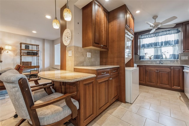 kitchen with pendant lighting, sink, ceiling fan, light tile patterned floors, and tasteful backsplash