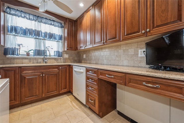 kitchen with ceiling fan, dishwasher, sink, light stone counters, and decorative backsplash