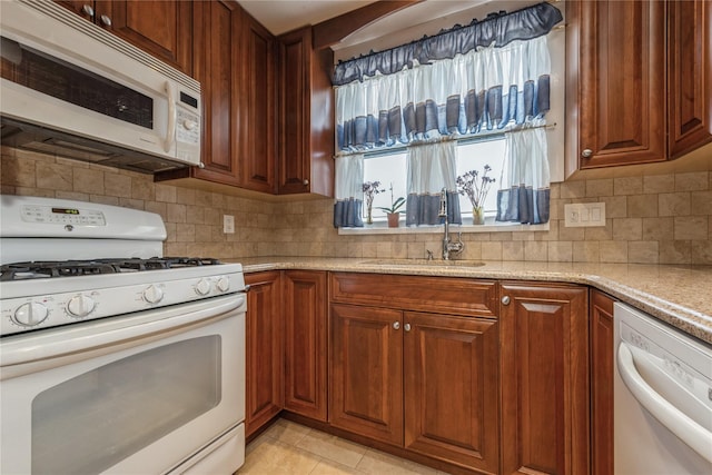 kitchen with white appliances, backsplash, sink, light stone countertops, and light tile patterned flooring