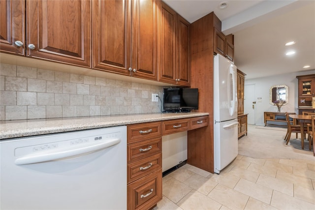 kitchen with light stone countertops, decorative backsplash, white appliances, and light tile patterned flooring