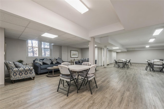 dining area with hardwood / wood-style floors and a drop ceiling