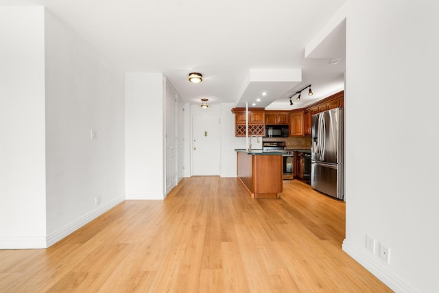 kitchen with a breakfast bar, light hardwood / wood-style flooring, tasteful backsplash, a kitchen island, and stainless steel appliances