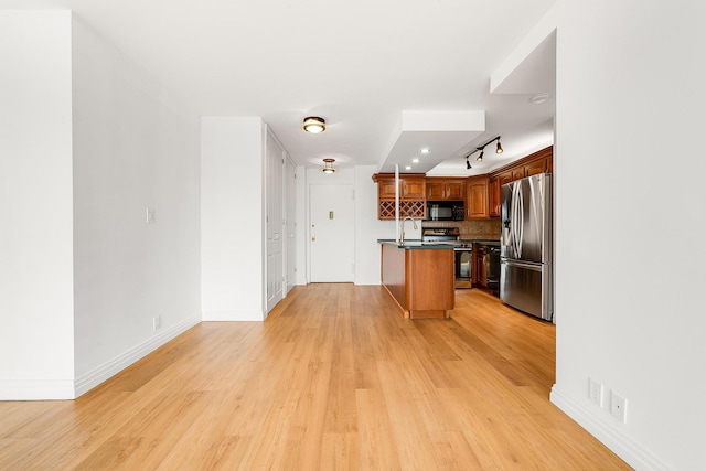 70-25 Yellowstone Blvd Unit 6O, Forest Hills, NY 11375 - kitchen featuring stainless steel appliances, dark countertops, light wood finished floors, and decorative backsplash