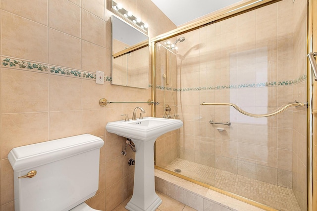 bathroom with tiled shower, tile patterned floors, toilet, and tile walls