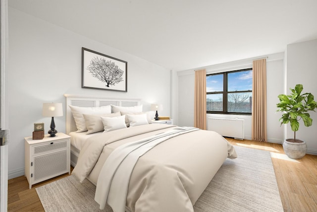 bedroom featuring light hardwood / wood-style floors and radiator