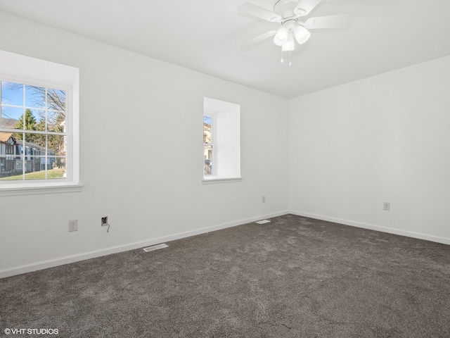 carpeted spare room featuring ceiling fan