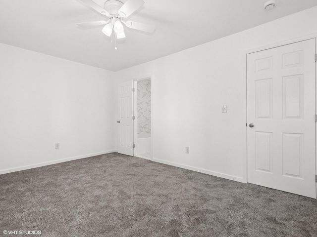 spare room with dark colored carpet and ceiling fan