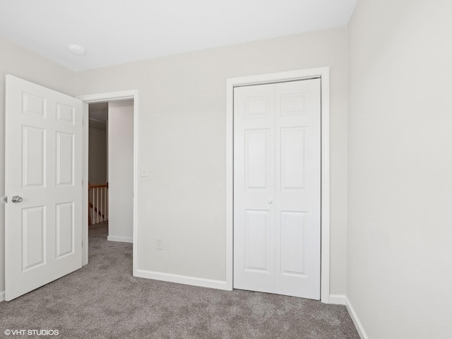 unfurnished bedroom with light colored carpet and a closet