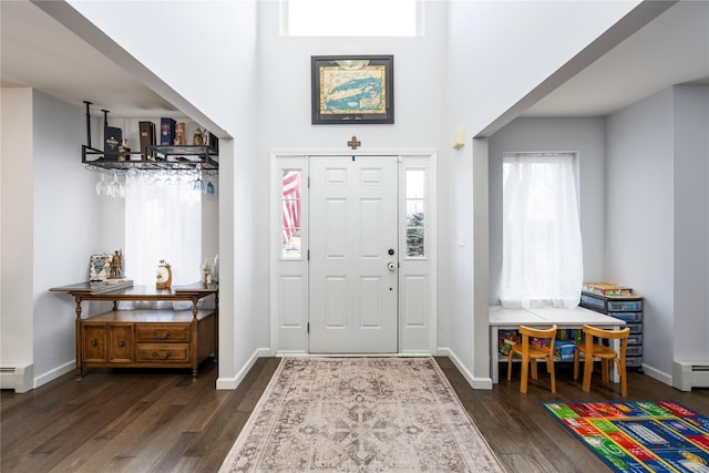 entrance foyer featuring dark hardwood / wood-style floors, a high ceiling, and baseboard heating