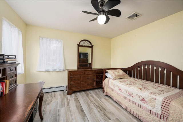 bedroom with a baseboard radiator, ceiling fan, and light wood-type flooring