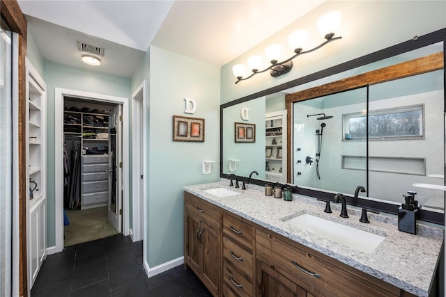 bathroom featuring vanity, tile patterned flooring, and walk in shower