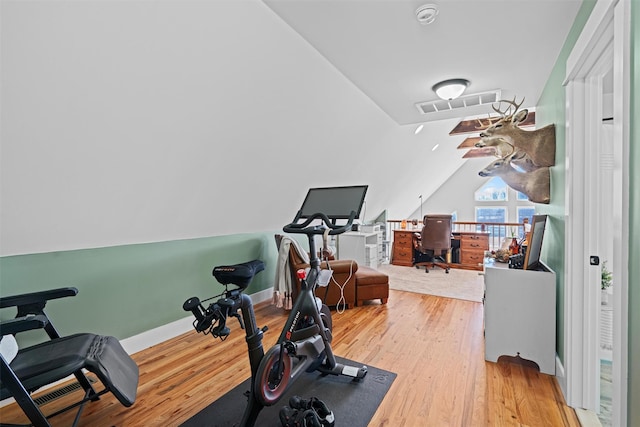 exercise area featuring wood-type flooring and lofted ceiling