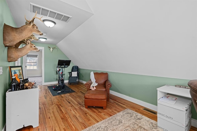 living area featuring wood-type flooring and vaulted ceiling