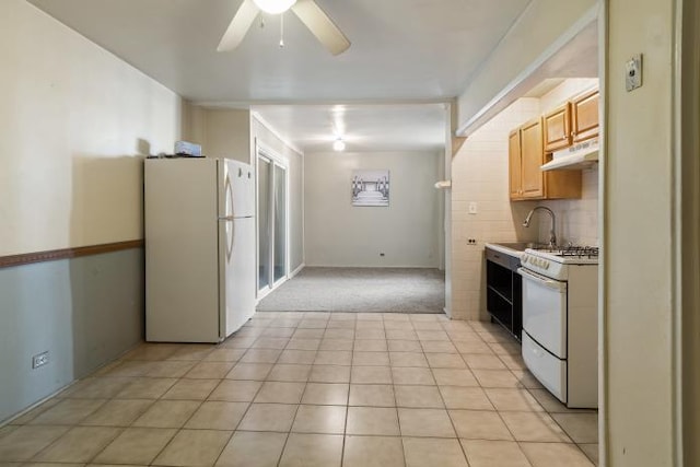 kitchen featuring ceiling fan, sink, white appliances, light carpet, and light brown cabinetry