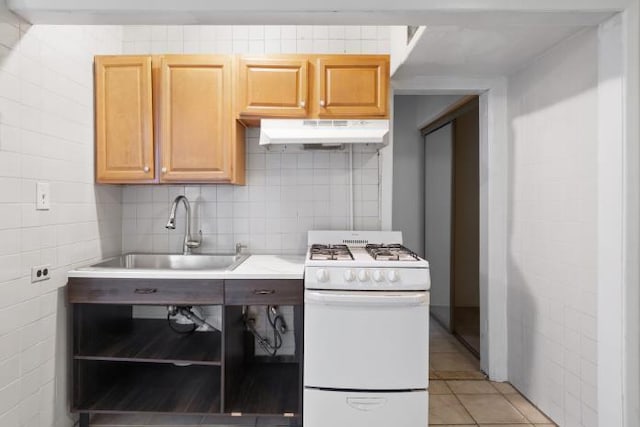 kitchen featuring decorative backsplash, light brown cabinetry, white gas range oven, sink, and light tile patterned floors