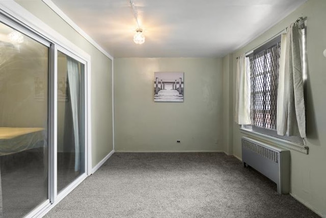 carpeted spare room featuring radiator