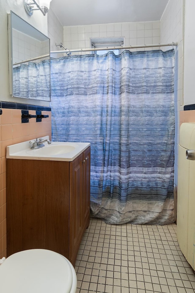 full bathroom featuring vanity, shower / bath combo, tile patterned floors, toilet, and tile walls