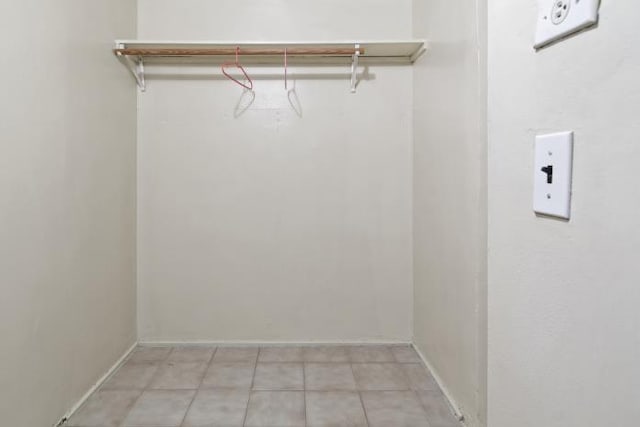 clothes washing area featuring light tile patterned flooring