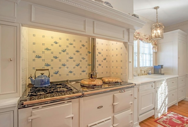 kitchen with light wood-type flooring, a sink, white cabinets, and backsplash