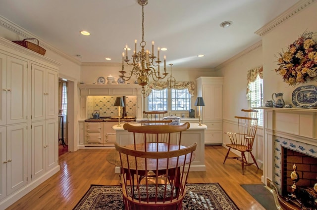 dining room featuring ornamental molding, recessed lighting, a fireplace, and light wood-style flooring