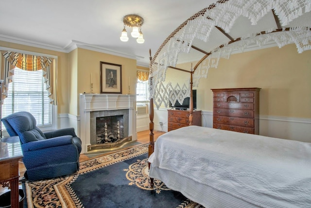 bedroom with a fireplace, wood finished floors, and crown molding