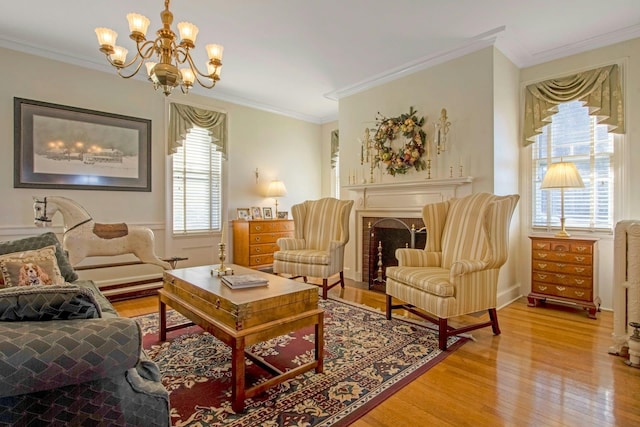 sitting room with light wood-style floors, crown molding, and a fireplace