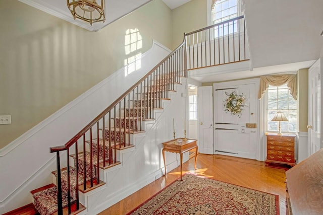 foyer entrance featuring a high ceiling, stairway, and wood finished floors