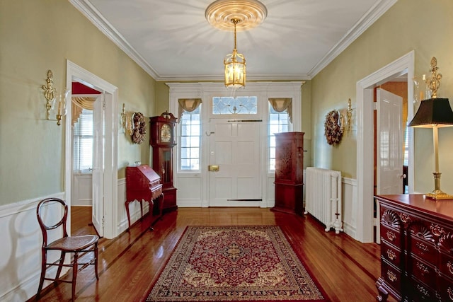 entryway featuring ornamental molding, radiator heating unit, and wood finished floors