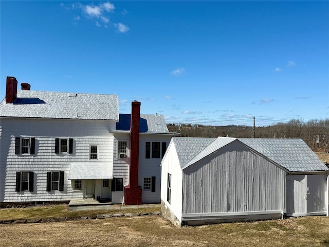 rear view of house featuring a chimney