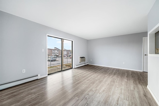 unfurnished living room with a wall mounted AC, a baseboard radiator, and wood-type flooring