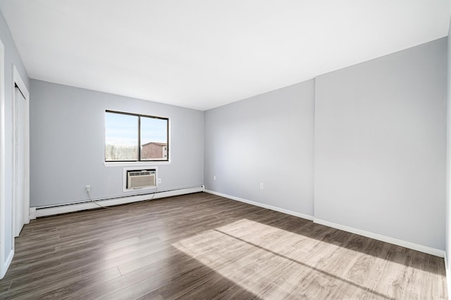 unfurnished room with wood-type flooring, an AC wall unit, and baseboard heating