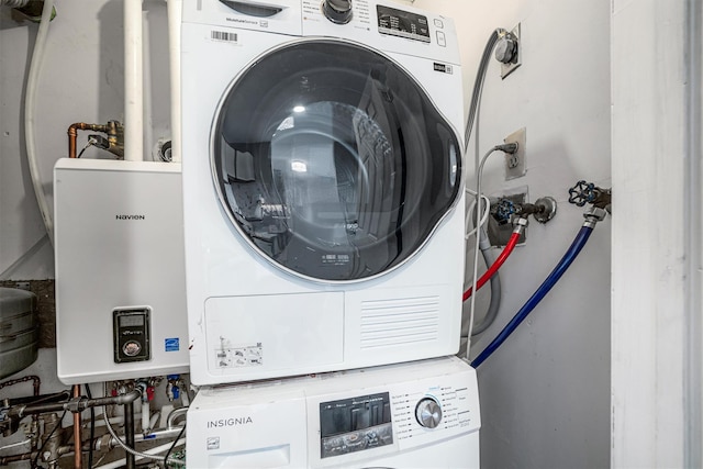 laundry area featuring stacked washer / drying machine and tankless water heater