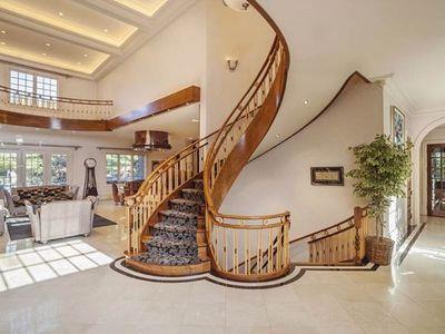 staircase with coffered ceiling, french doors, tile patterned flooring, a towering ceiling, and ornamental molding