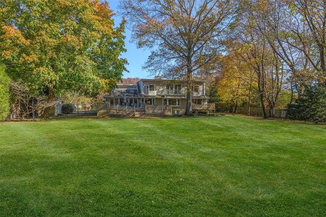 view of yard featuring a balcony and a wooden deck