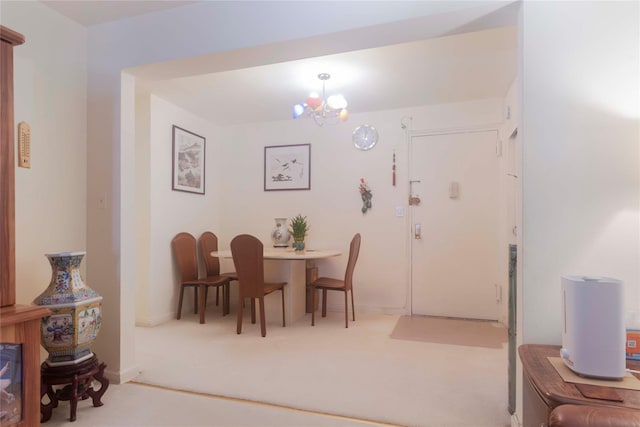 dining area featuring light colored carpet and an inviting chandelier