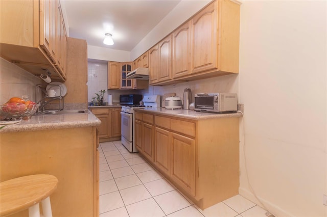 kitchen featuring light brown cabinetry, light tile patterned floors, white range with gas cooktop, and sink