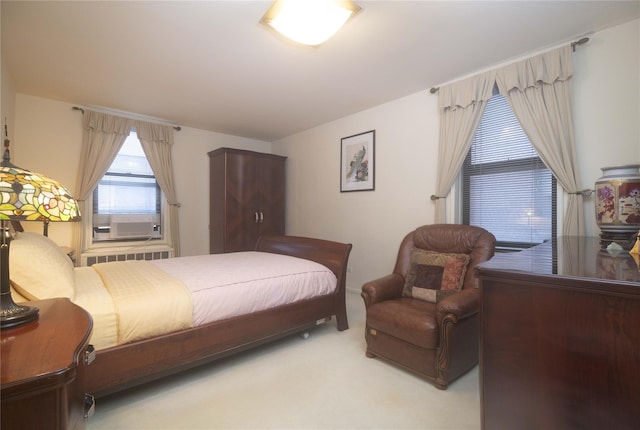 bedroom featuring light carpet, radiator heating unit, and cooling unit