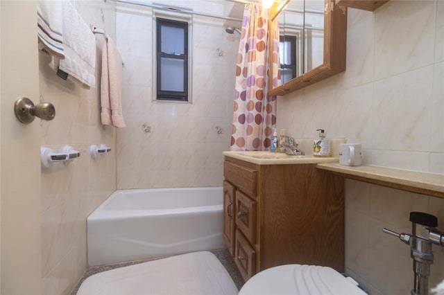 bathroom with shower / bath combo, vanity, tasteful backsplash, and tile walls