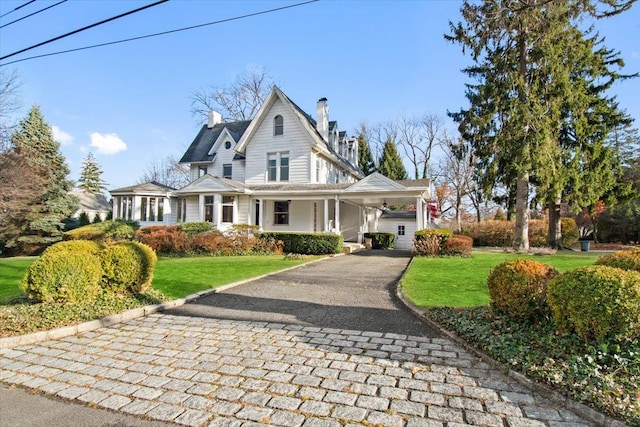 view of front of house with a front lawn and a carport