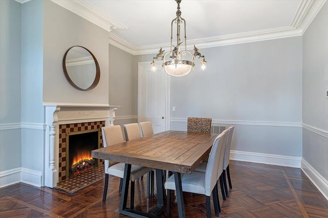 dining space featuring dark parquet flooring, an inviting chandelier, and ornamental molding