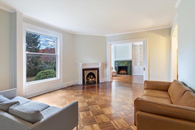 living room with built in shelves, parquet flooring, and ornamental molding