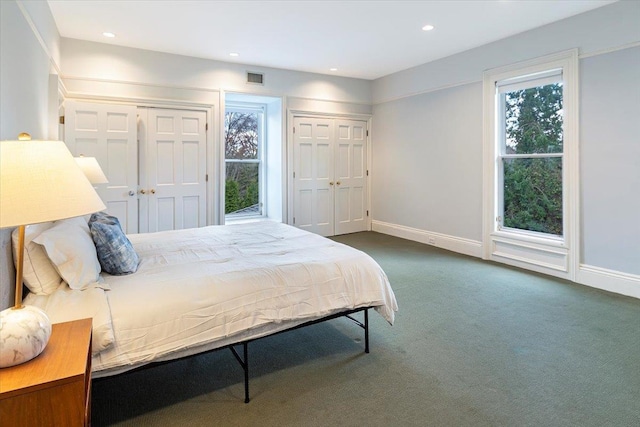 carpeted bedroom with multiple closets