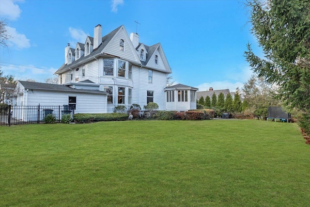 back of house with a lawn and a sunroom