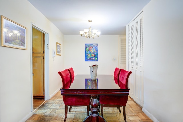 dining area with light parquet floors and a chandelier