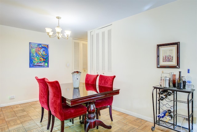 dining space with light parquet floors and an inviting chandelier