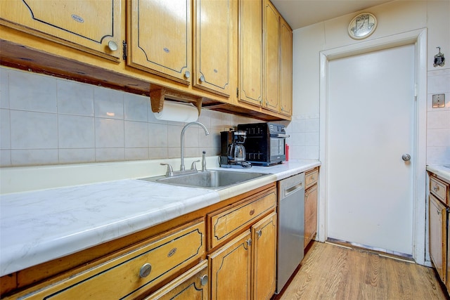 kitchen featuring dishwasher, sink, and light hardwood / wood-style flooring