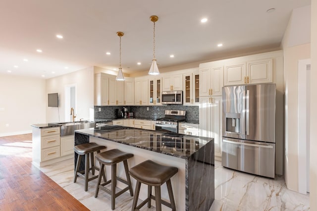 kitchen featuring decorative backsplash, a center island, sink, and stainless steel appliances