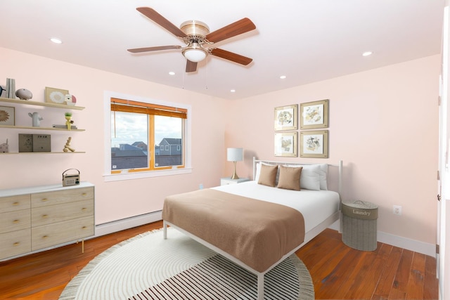 bedroom featuring wood-type flooring, ceiling fan, and a baseboard heating unit