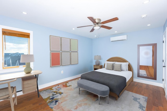 bedroom with a wall mounted AC, ceiling fan, and hardwood / wood-style flooring