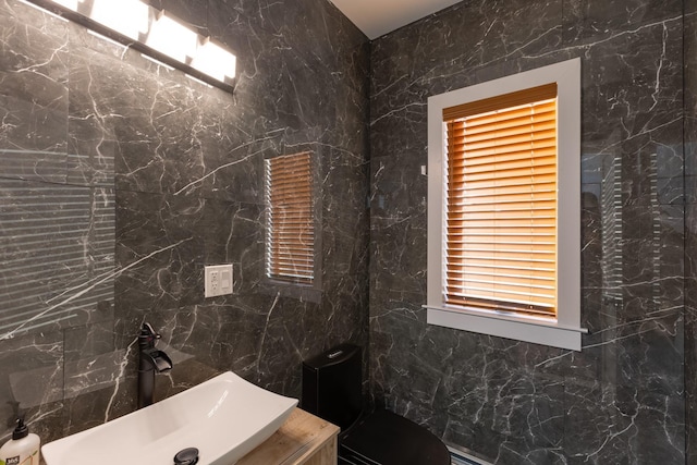 bathroom with sink and tile walls